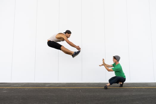 Two acrobats doing tricks together, jumping mid-air photo