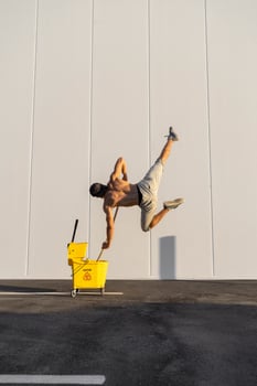 Acrobat playing with cleaning bucket and mop photo