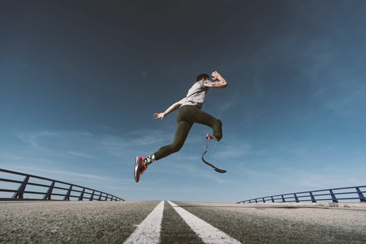 Disabled athlete with leg prosthesis exercising on a road photo
