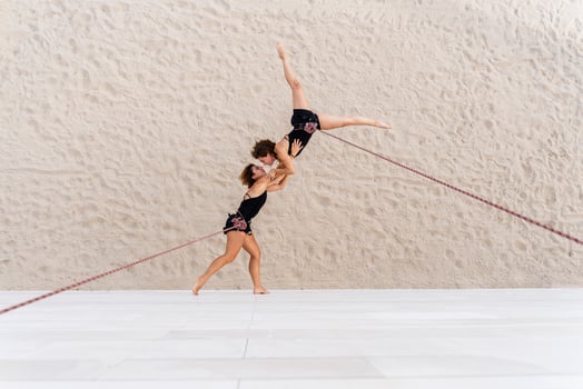 Aerial dancers dancing while hanging against wall photo