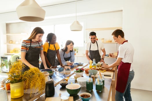Friends and instructor in a cooking workshop preparing food photo