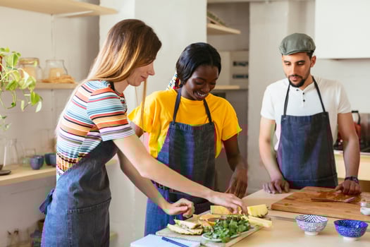 Friends preparing pineapple in kitchen photo