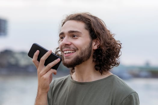 Portrait of happy young man using smartphone outdoors photo