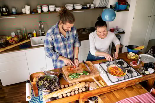 Young couple preparing food together, tasting spaghetti photo