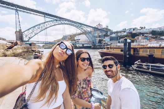Cheerful young friends taking selfie against Douro River in city, Porto, Portugal photo