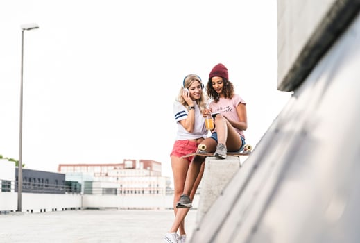 Best friends with skateboard, having fun together, listening music photo