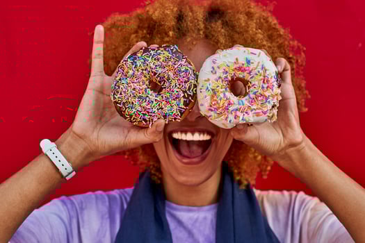 Playful woman holding two donuts in front of her eyes photo