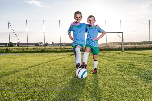 Smiling young football players embracing on football ground photo