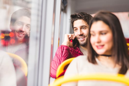UK, London, portrait of smiling young man on the phone in a bus photo