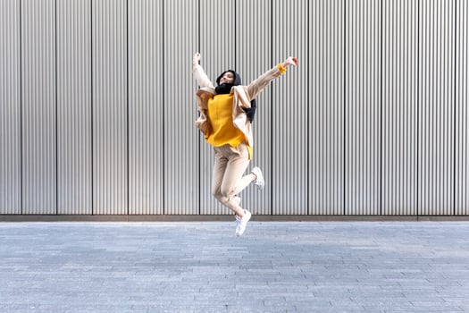 Portrait of happy young woman jumping in the air photo