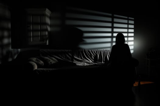 Shadowy figure looming over sleeping figure background with empty space for text photo