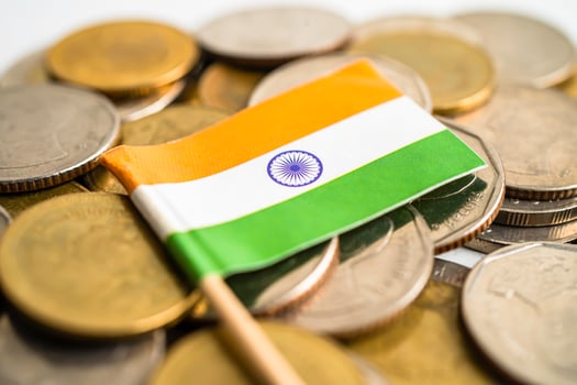 Stack of coins with India flag and US dollar banknotes. photo