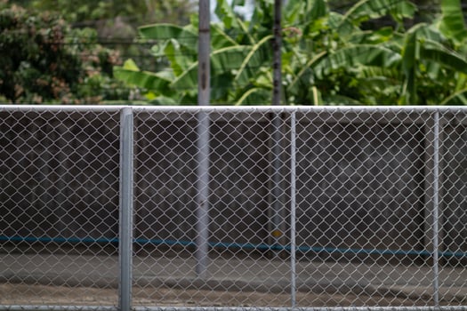 Steel mesh is used as temporary fence to mark boundaries of private property because it is durable and easy install as fence. steel mesh background is installed to prevent intrusion and has copy space photo