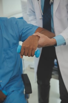 Physiotherapist man giving exercise with dumbbell treatment About Arm and Shoulder of athlete male patient Physical therapy concept photo
