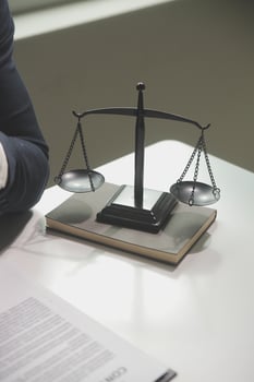 Business and lawyers discussing contract papers with brass scale on desk in office. Law, legal services, advice, justice and law concept picture with film grain effect photo