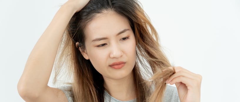 Asian woman very sad and upset looking at damaged hair, hair loss, hair thinning problem, vitamin deficiency, baldness, postpartum, biotin, zinc, menstrual or endocrine disorders, hormonal imbalance photo