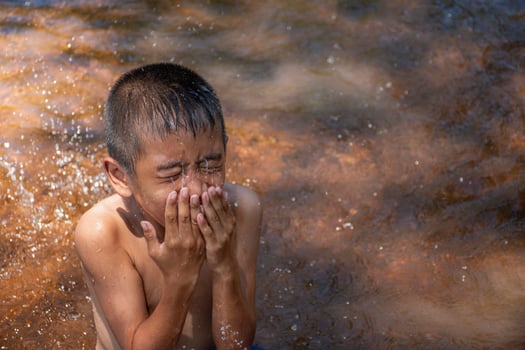 Asian young boy cute and charming washing face in river on background water surface and sunrises,child playing water,Lifestyle of asian children,Concept of life and sustainability. photo