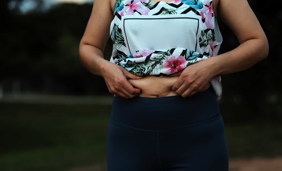 Women body fat belly. Obese woman hand holding excessive belly fat. diet lifestyle concept to reduce belly and shape up healthy stomach muscle. photo
