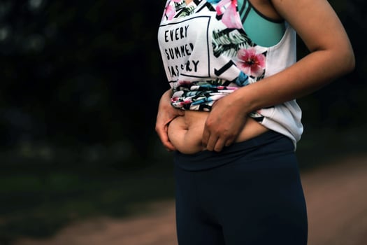 Women body fat belly. Obese woman hand holding excessive belly fat. diet lifestyle concept to reduce belly and shape up healthy stomach muscle. photo