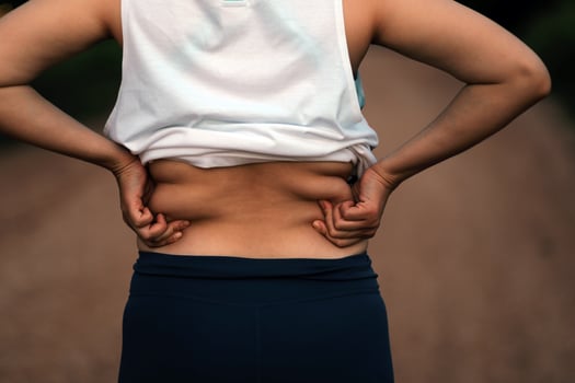 Women body fat belly. Obese woman hand holding excessive belly fat. diet lifestyle concept to reduce belly and shape up healthy stomach muscle. photo