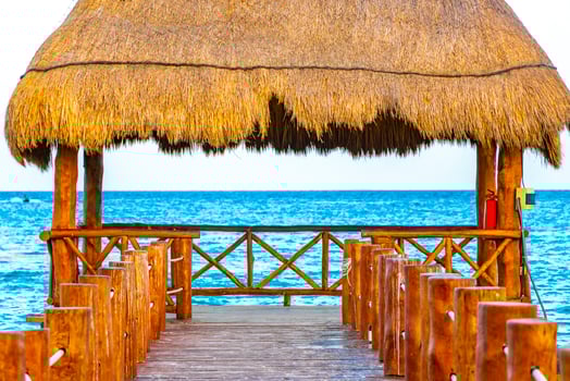 Tropical Caribbean beach clear turquoise water jetty Playa Xcalacoco Mexico. photo