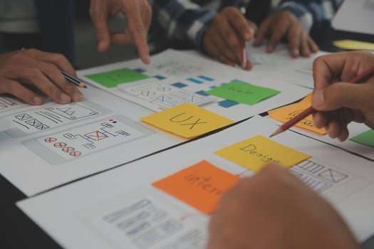 Close up ux developer and ui designer brainstorming about mobile app interface wireframe design on table with customer breif and color code at modern office.Creative digital development agency photo