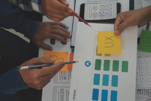 Close up ux developer and ui designer brainstorming about mobile app interface wireframe design on table with customer breif and color code at modern office.Creative digital development agency photo