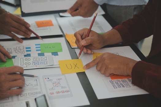 Close up ux developer and ui designer brainstorming about mobile app interface wireframe design on table with customer breif and color code at modern office.Creative digital development agency photo