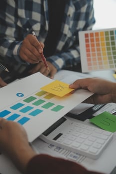 Close up ux developer and ui designer brainstorming about mobile app interface wireframe design on table with customer breif and color code at modern office.Creative digital development agency photo