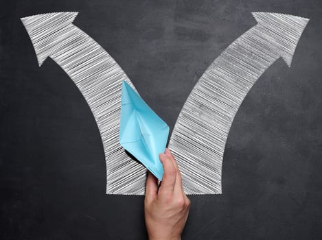Hand holding a blue paper boat, concept of finding solutions, choosing direction of movement photo