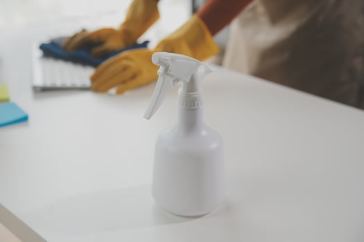Office Cleaning Service. Janitor Spraying Desk. Workplace Hygiene photo