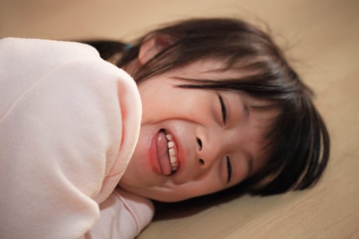 Joyful Asian Child Happy Girl Radiates Cheer on Cozy Home Floor photo