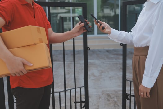 Asian Woman Receiving Product from delivery man at Home, Young Owner Woman Order Product from Smartphone Application, Woman with Online Business or SME Concept. photo