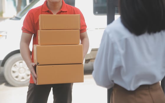 Asian Woman Receiving Product from delivery man at Home, Young Owner Woman Order Product from Smartphone Application, Woman with Online Business or SME Concept. photo
