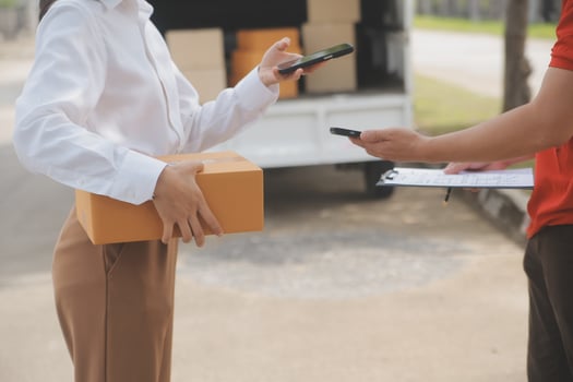 Asian Woman Receiving Product from delivery man at Home, Young Owner Woman Order Product from Smartphone Application, Woman with Online Business or SME Concept. photo