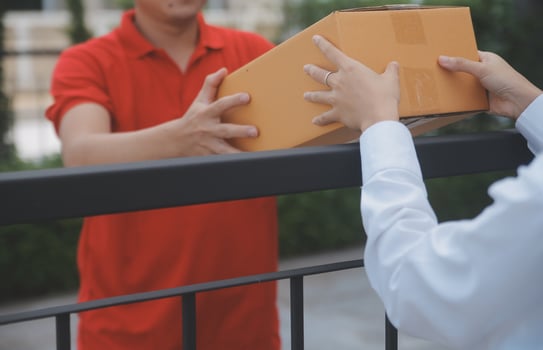Asian Woman Receiving Product from delivery man at Home, Young Owner Woman Order Product from Smartphone Application, Woman with Online Business or SME Concept. photo