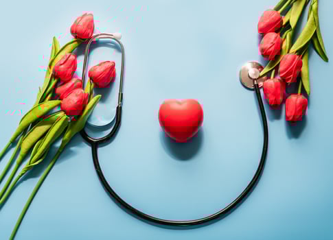 Stethoscope, tulips, on blue background. Greeting background. Happy nurse's day. Health day. National doctor's day. Top view, Closeup. Thank you, doctors and nurses photo