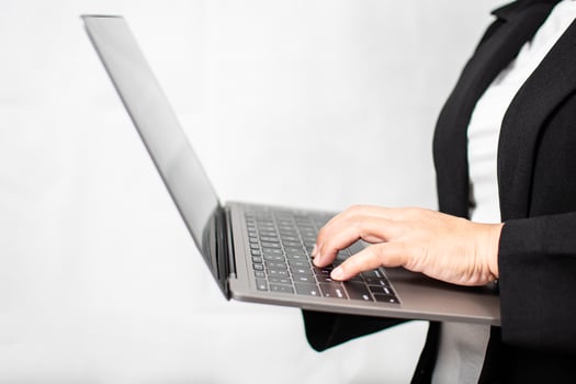 A businesswoman in a suit is using a laptop to work and typing at a keyboard. Concept for Marketing, Finance, Banking, Equity, Stock Trading. woman hold notebook computer Close Up, blurred background photo