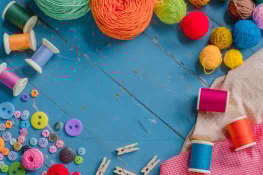 Sewing background. Accessories for needlework on blue wooden background. photo