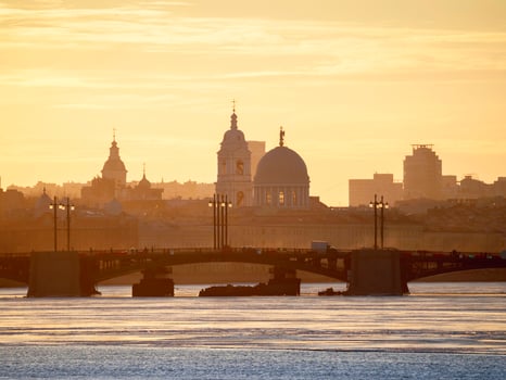 Golden spring sunset over the bridge. Saint Petersburg cityscape over Neva River in Russia. City skyline colorful photo with historical Russian architecture. Postcard view of the city.