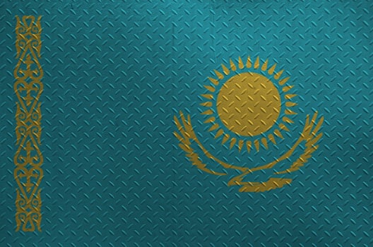 Kazakhstan flag depicted in paint colors on old brushed metal plate or wall closeup. Textured banner on rough background photo