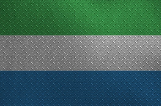 Sierra Leone flag depicted in paint colors on old brushed metal plate or wall closeup. Textured banner on rough background photo