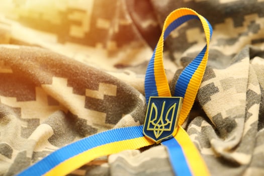 Military camouflage fabric with ukrainian stripes on ribbon photo