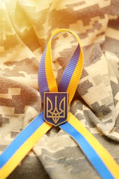 Military camouflage fabric with ukrainian stripes on ribbon photo