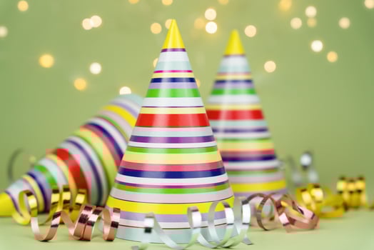 Colored party hats for holiday party on green background. Copy space. Close-up. photo