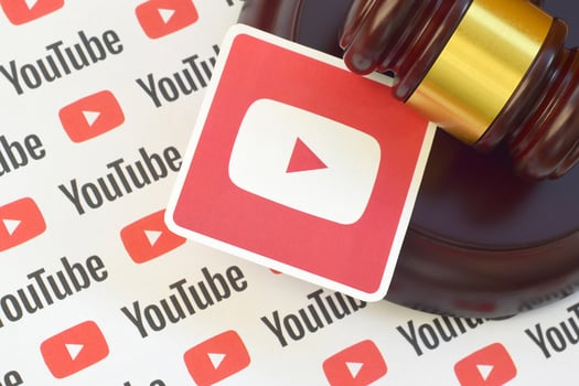 Youtube paper logo lies with wooden judge gavel. Entertainment lawsuit concept photo