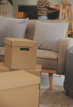 Beautiful young couple in love having fun unpacking things from cardboard boxes while moving in together in their new apartment photo