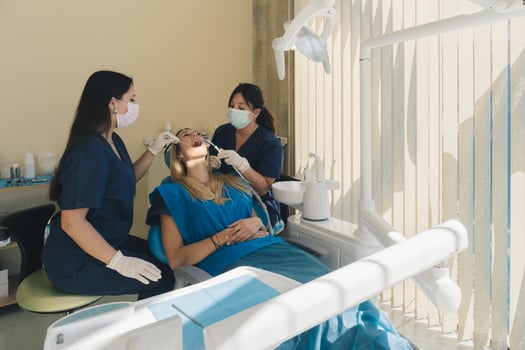 Dentists examining female patient teeth and having a dental checkup at the hospital. photo