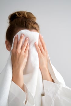 The girl wipes her face with a terry towel. photo