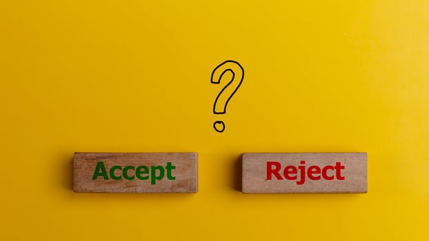 The words accept and reject on wooden blocks with question mark symbols. Dilemma or choice between to approve or to refuse an application concept. photo